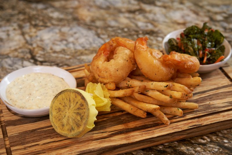 A plate of shrimp and fries sitting on a table
