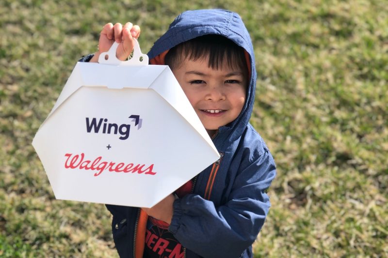Noah Coffren holds an order from Walgreens, delivered by Wing to the backyard of his Christiansburg home. Photo courtesy of Zach and Rommelyn Coffren