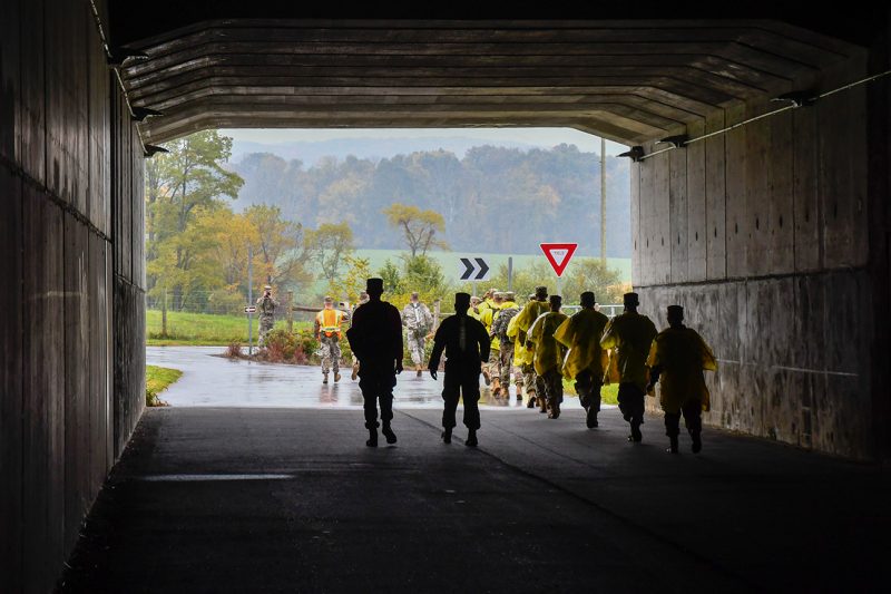 Cadets walk through a concrete tunnel.