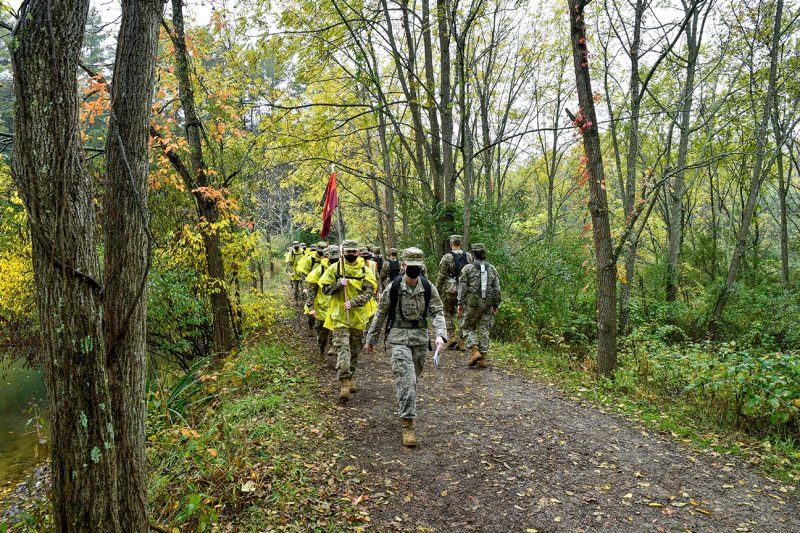 Cadets walk along a wooded trail.