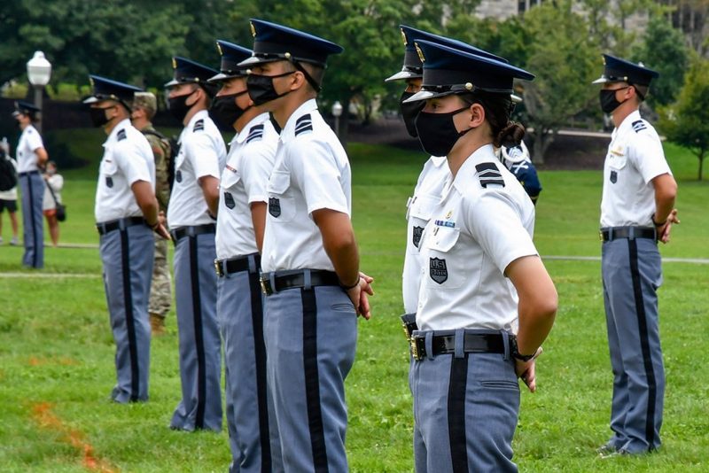 Cadet Erin Cross-Kaplan, at right, stands at parade rest in a line of cadets on the Drillfield during a military parade.
