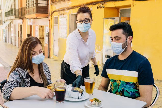 image of people at restaurant with masks on 