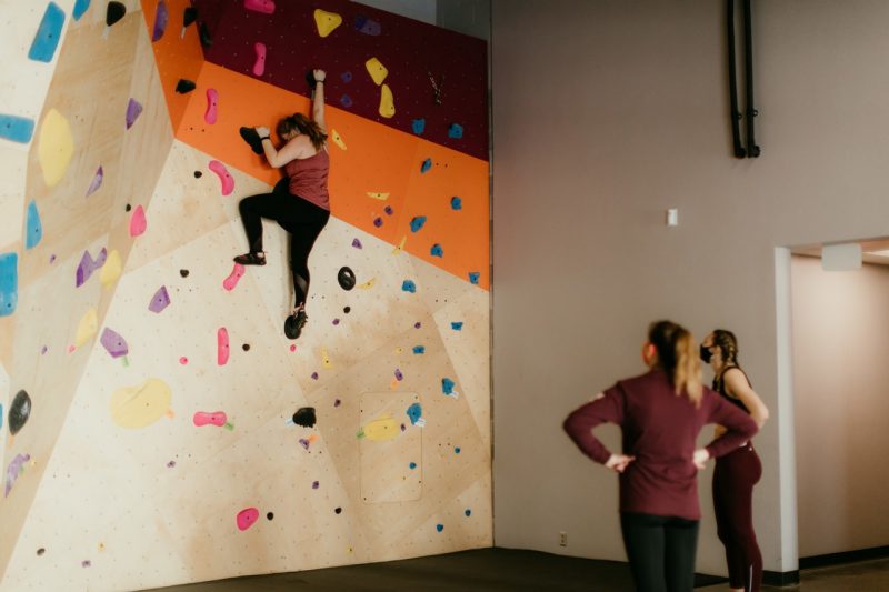 people climbing on indoor rock wall