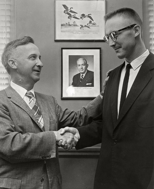 Executive Director of the Virginia Department of Game and Inland Fisheries Chester Phelps congratulates Cutler on his promotion to Chief of the Education Division of the department, 1960.