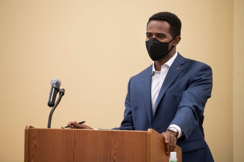 image of Awad Abdelhalim at a podium wearing a mask