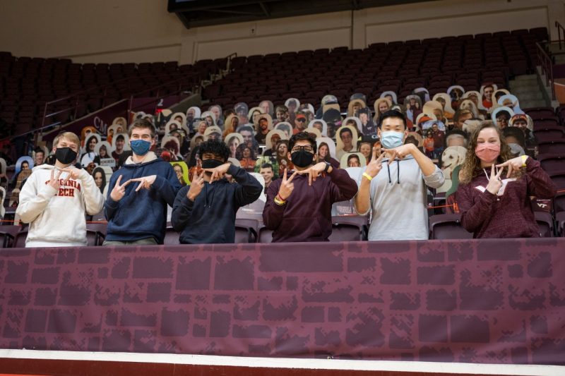 Some members of the American Society of Mechanical Engineers at Virginia Tech pose in front of the cutouts at Cassell Coliseum that they designed to move back and forth. The students are (from left to right)  Eric Link, Kieran Beaumont, Raunak Ahmed, Pratik Satija, Andrew Choi, and Molly Maranto. Photo by Ryan Young.