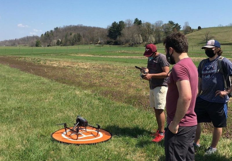 Matt Darrah, Grady Hesse, and Ryan Humphry use a drone at Homefield Farm to measure soil moisture.