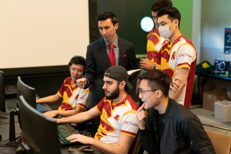 Joe Jacko (in suit and tie) coaches the University of SoutheJoe Jacko (in suit and tie) coaches the University of Southern California’s varsity League of Legends team.