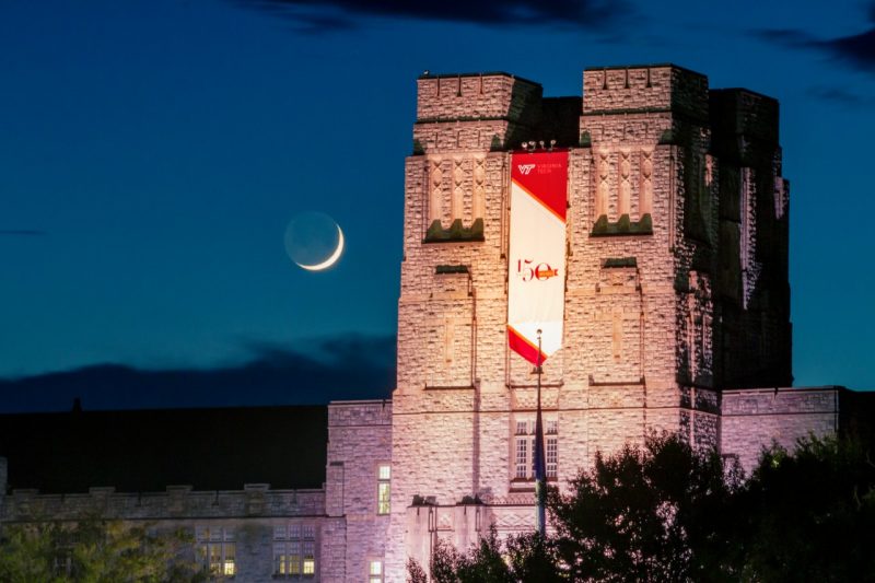 Burruss Hall is seen with a crescent moon in the backdrop