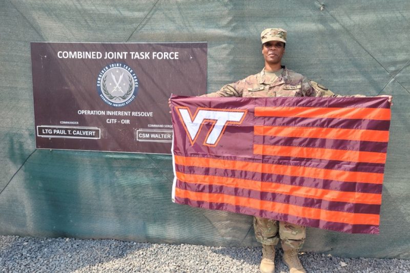 U.S. Navy Lt. Cmdr. Ebony Wilson Rankin holds a Virginia Tech flag.