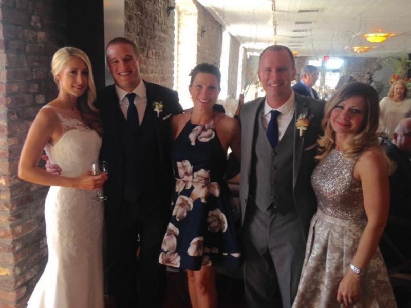 Five members of the Quillen family dressed in formal wear smile at Matt and Kelsey Quillen's wedding.