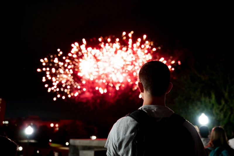 student watching fireworks over the Drillfield
