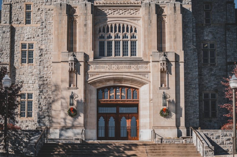 Burruss Hall is seen adorned with Christmas wreaths on either side of the front entrance