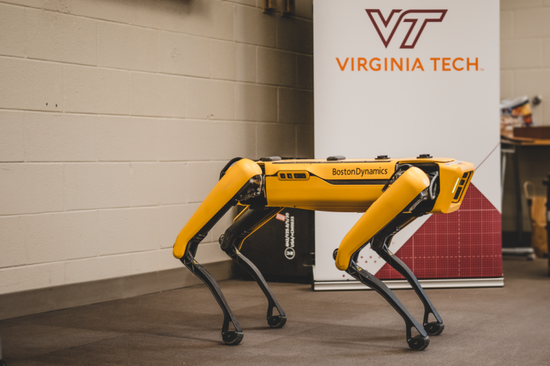 Spot robotic dog with Virginia Tech standup banner in background
