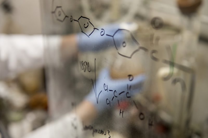 Photo of chemical structures drawn on the glass panels of a fume hood. 