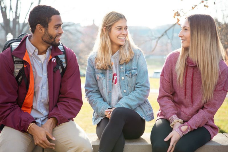 Three students chatting outside of Burruss Hall.