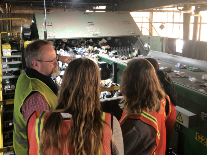 Student interns tour RDS recycling facility (sorting machines in background)