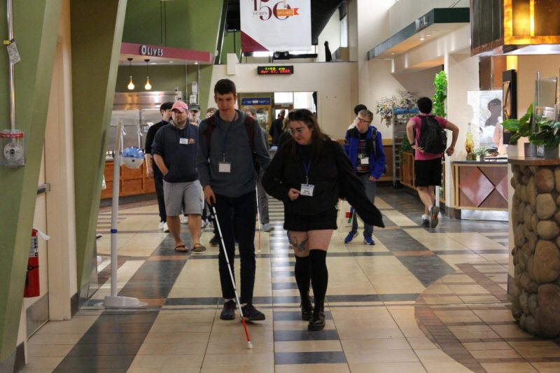 Kelly Casey, a Virginia Tech architecture student, walks with Gabriel Patterson, a high school student from Fairfax, in Dietrick Hall on campus. Photo by Andrew Gipe-Lazarou.