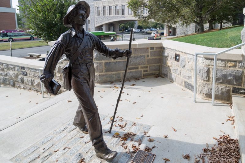 A statue of Addison Caldwell stands up a flight of stairs that lead from Alumni Mall to the Upper Quad.