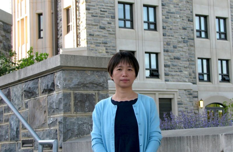 Ying Zhou, from the Virginia Tech Department of Geosciences, stands in front of the New Classroom Building on the Virginia Tech campus.