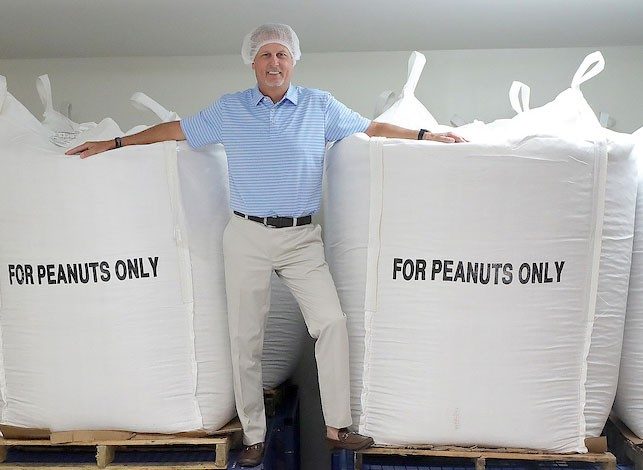 Todd Smith stands beside 2,200-pound totes delivered for processing. Photo courtesy of Consociate Media.