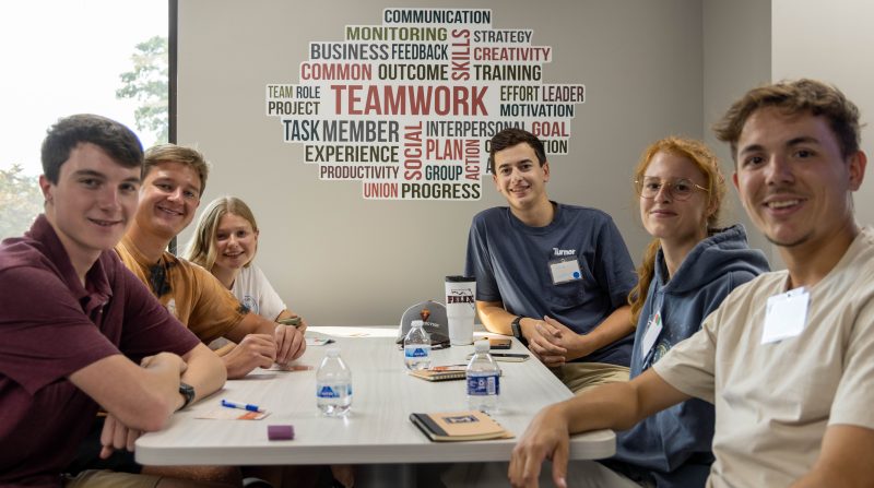 Six students posed around table at Apex Startup Weekend in September