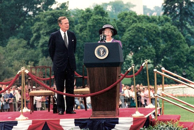 Queen Elizabeth stands behind a podium.