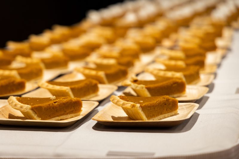 Rows of pumpkin pie slices on a buffet table.