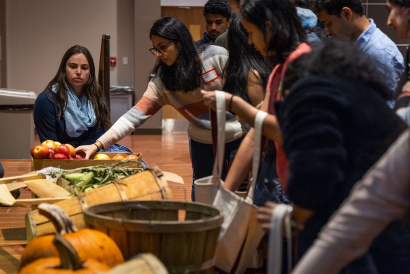 International students at the Gratitude Feast choose local produce to take with them.