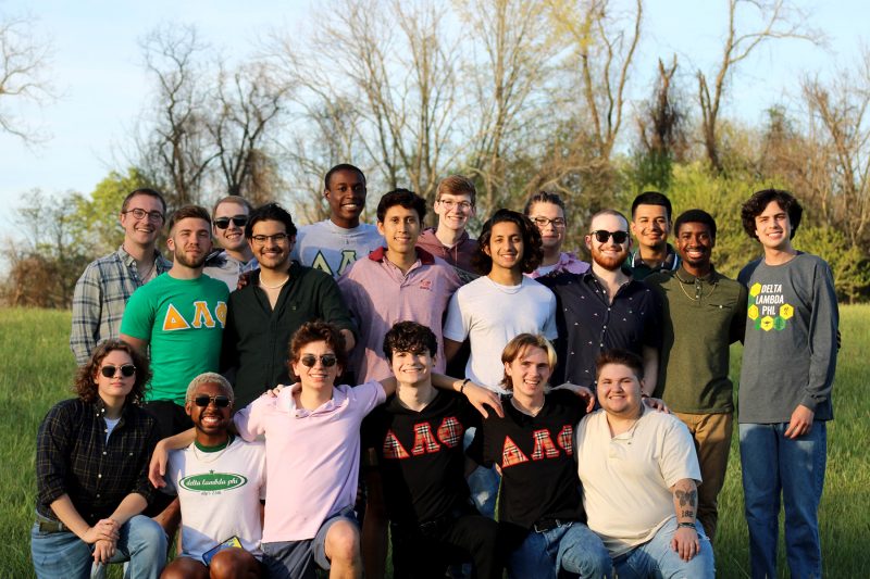 Members of the Delta Lambda Phi fraternity stand together outside for a group photo.