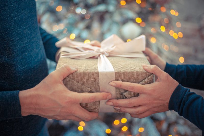 Two people holding a gift