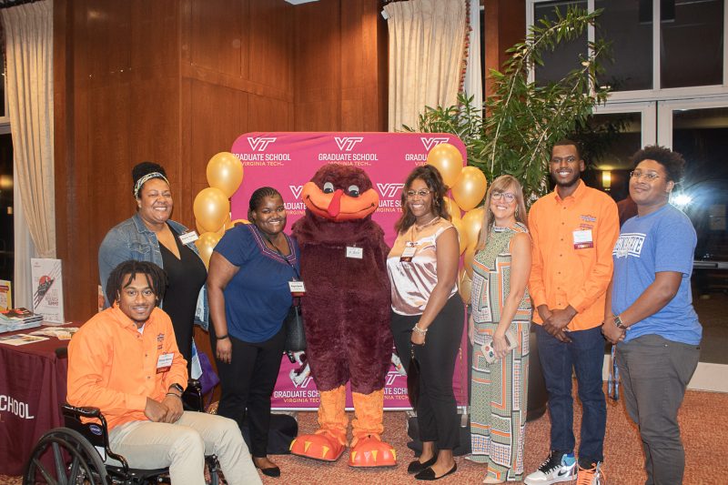 Students and staff stand with Hokie Bird